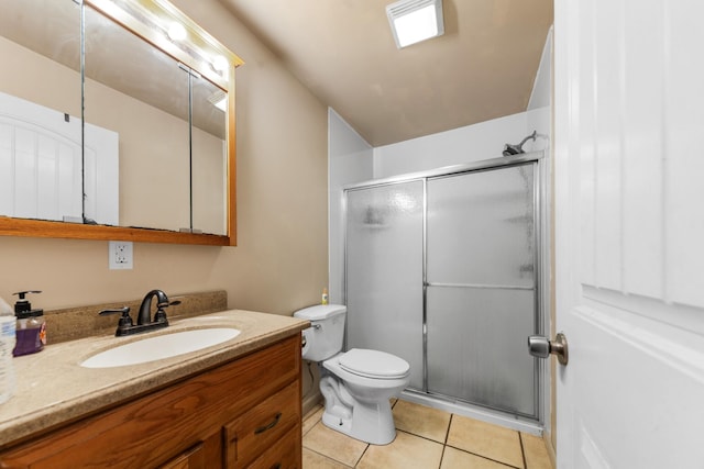 bathroom featuring vanity, toilet, a shower with shower door, and tile patterned flooring