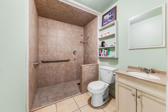 bathroom featuring tile patterned floors, vanity, toilet, and a tile shower