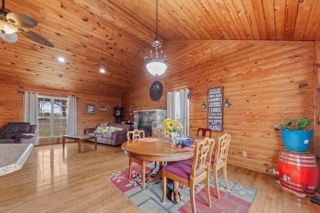 dining space featuring ceiling fan, wood walls, light hardwood / wood-style flooring, and wooden ceiling