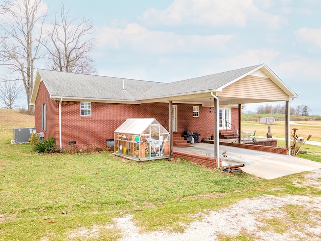 rear view of property featuring a yard, an outdoor structure, and a patio