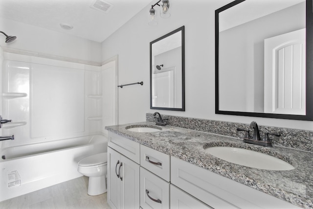 full bath featuring toilet, double vanity, a sink, and visible vents