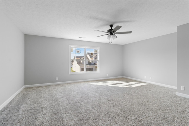 empty room featuring carpet, visible vents, ceiling fan, a textured ceiling, and baseboards