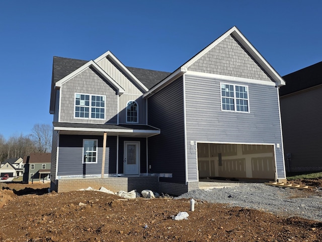 craftsman-style house with a garage, driveway, board and batten siding, and covered porch