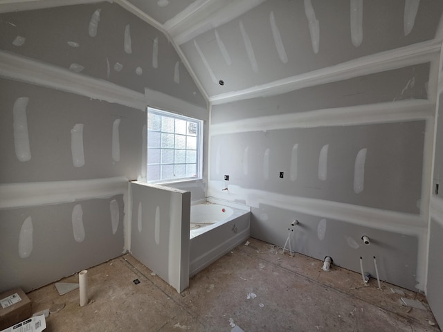 bathroom with lofted ceiling and a bath