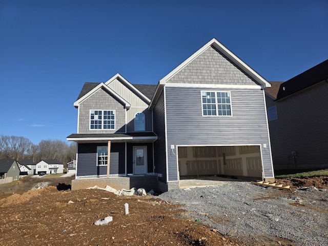 view of front of house featuring board and batten siding, gravel driveway, and an attached garage