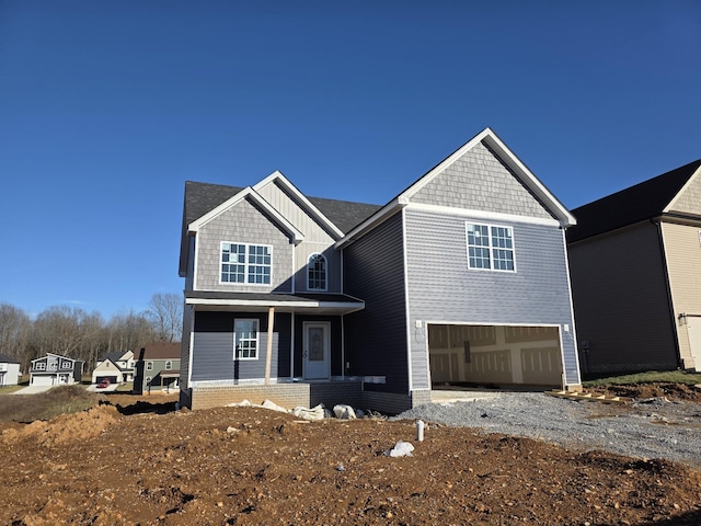 view of front of property with a garage, board and batten siding, and gravel driveway