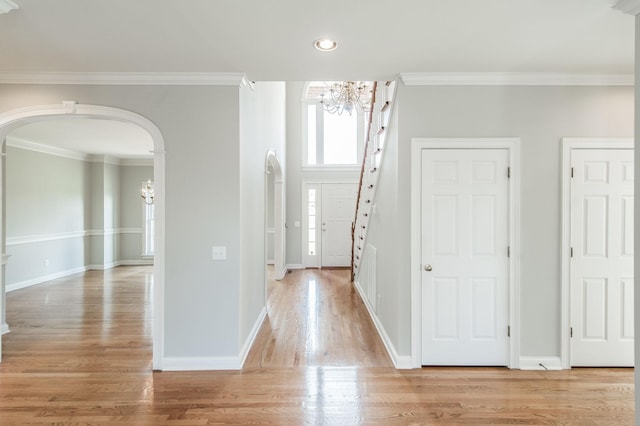 entryway featuring ornamental molding, a chandelier, and light hardwood / wood-style floors