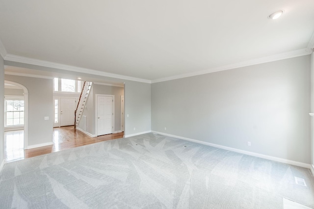 unfurnished room featuring crown molding and light colored carpet