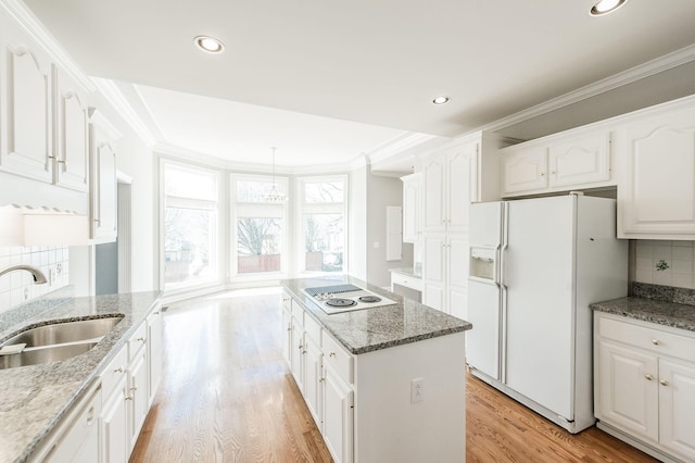 kitchen featuring stone counters, a kitchen island, white cabinetry, sink, and white appliances