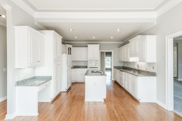 kitchen with an island with sink, sink, light wood-type flooring, white cabinets, and white appliances