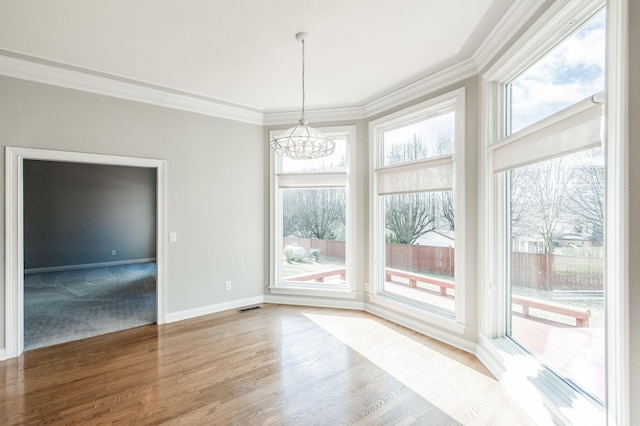 unfurnished dining area with a notable chandelier, hardwood / wood-style flooring, and ornamental molding