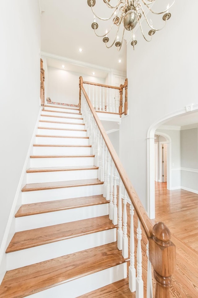 staircase with hardwood / wood-style flooring and an inviting chandelier