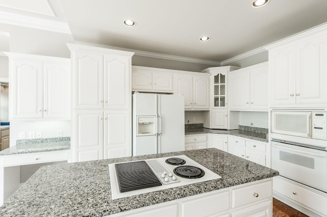 kitchen featuring white cabinetry, tasteful backsplash, dark stone countertops, ornamental molding, and white appliances