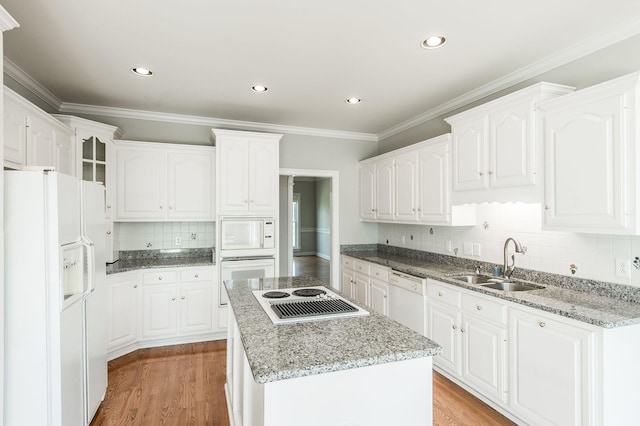 kitchen with white cabinetry, sink, white appliances, and a kitchen island