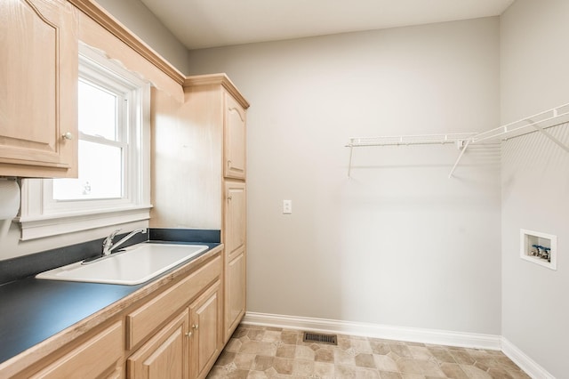 laundry room featuring hookup for a washing machine, sink, and cabinets