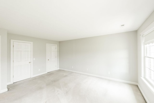 interior space with multiple windows and light carpet