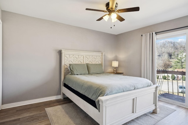 bedroom featuring multiple windows, dark wood-type flooring, and access to outside