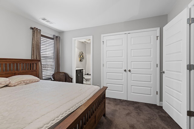 carpeted bedroom featuring ensuite bathroom and a closet