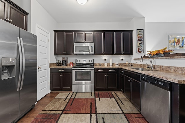 kitchen with dark brown cabinetry, sink, and stainless steel appliances