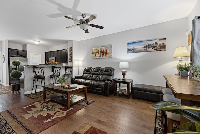 living room with dark wood-type flooring and ceiling fan