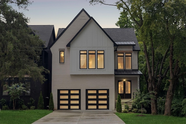 modern farmhouse style home with a garage and a lawn