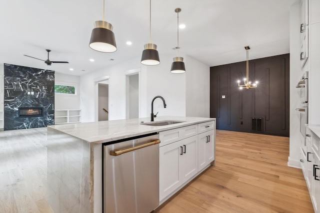 kitchen with pendant lighting, white cabinetry, sink, a kitchen island with sink, and stainless steel appliances