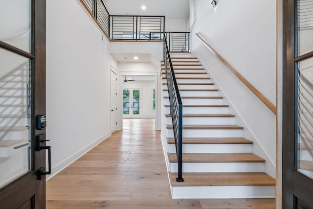 foyer featuring a towering ceiling, light hardwood / wood-style flooring, and french doors