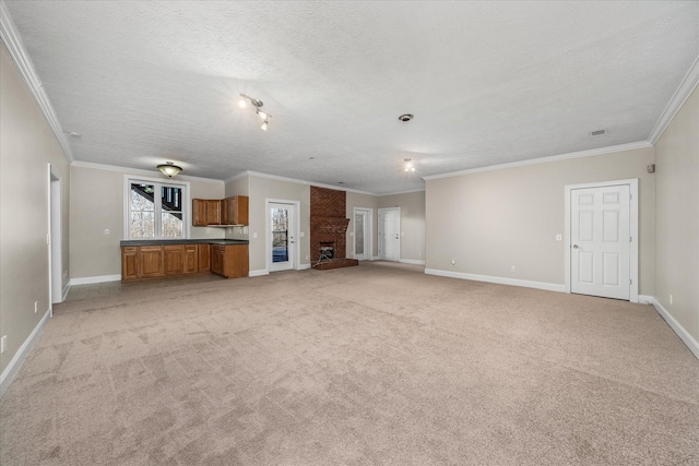 unfurnished living room with crown molding, light colored carpet, a brick fireplace, and a textured ceiling