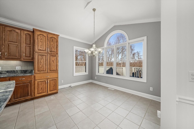 unfurnished dining area featuring vaulted ceiling, ornamental molding, light tile patterned flooring, and a chandelier