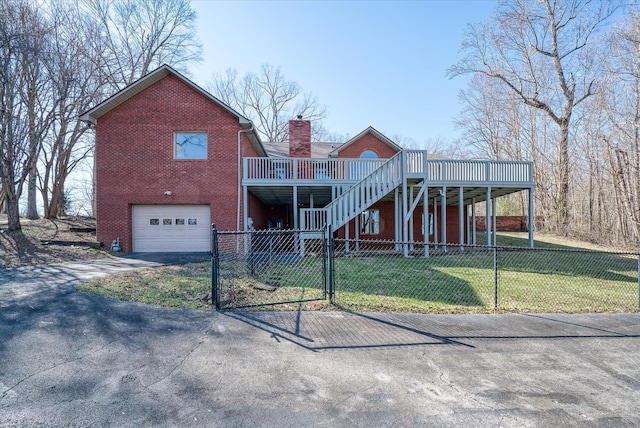 view of front facade with a garage, a wooden deck, and a front lawn