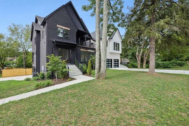 view of front of home featuring a garage, a balcony, and a front yard