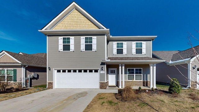 craftsman-style home featuring a garage, stone siding, and concrete driveway