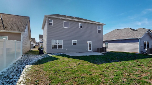 rear view of house with central AC unit, fence, a lawn, and a patio