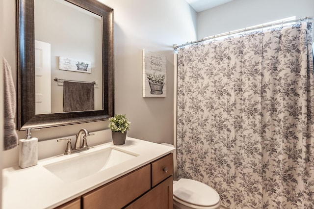 bathroom featuring walk in shower, vanity, and toilet