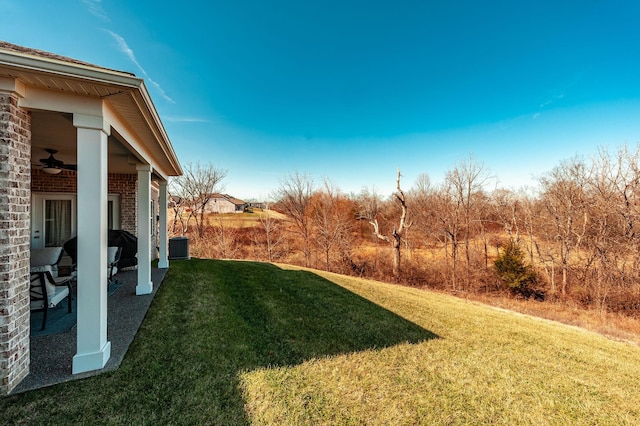 view of yard with central AC unit and ceiling fan