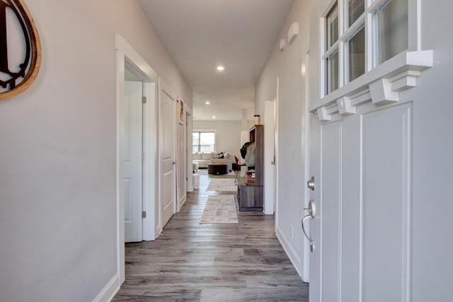 corridor with recessed lighting, baseboards, and wood finished floors