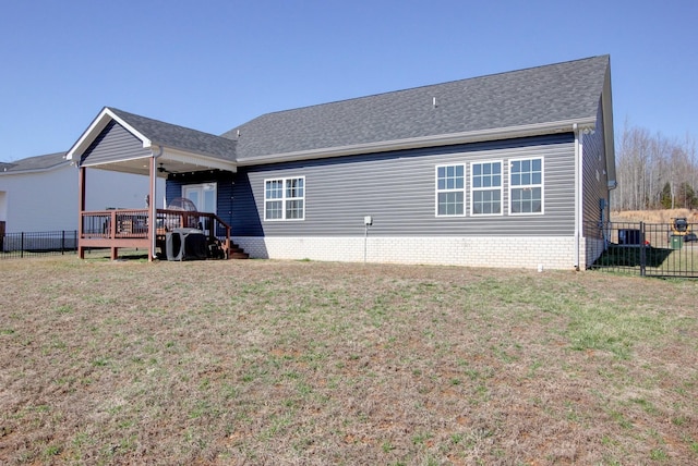 back of house featuring brick siding, fence, and a yard