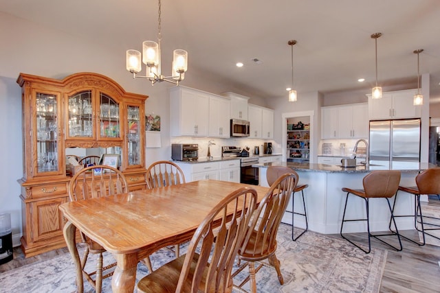 dining space with light wood finished floors, visible vents, a notable chandelier, and recessed lighting