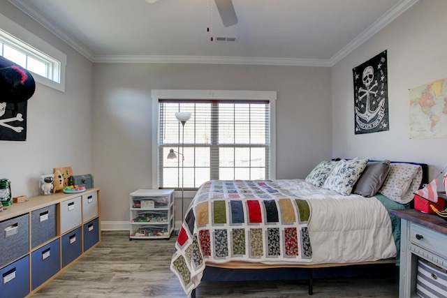 bedroom with ceiling fan, visible vents, crown molding, and wood finished floors