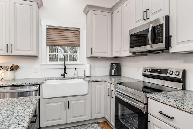 kitchen with white cabinetry, stainless steel appliances, and sink