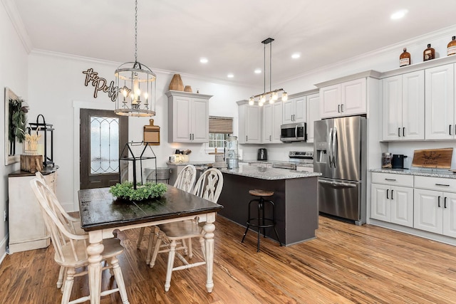 dining area featuring crown molding, plenty of natural light, a notable chandelier, and light hardwood / wood-style flooring