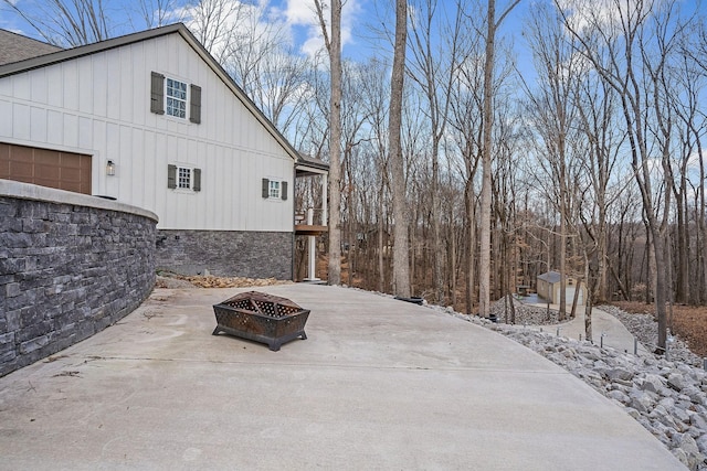 exterior space featuring a balcony, an outdoor fire pit, and a garage