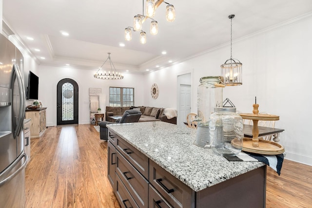 kitchen featuring a kitchen island, stainless steel fridge with ice dispenser, light hardwood / wood-style floors, a tray ceiling, and dark brown cabinets