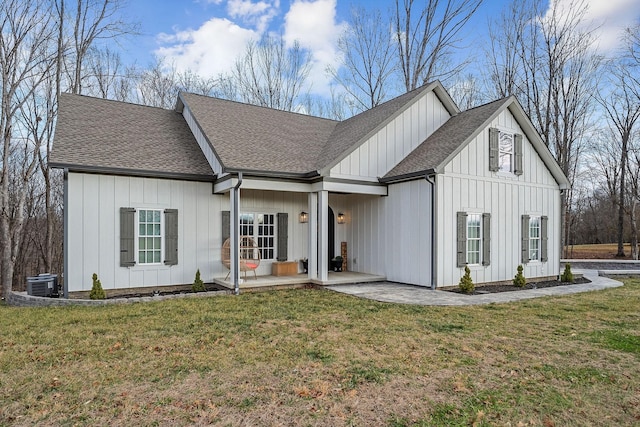 view of front of home with cooling unit and a front lawn