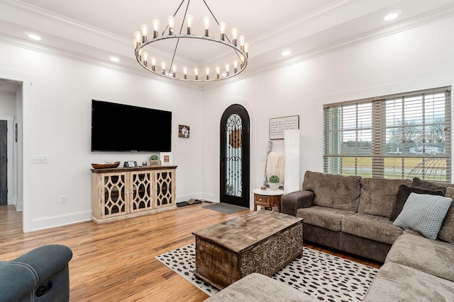 living room with crown molding, a raised ceiling, and hardwood / wood-style floors