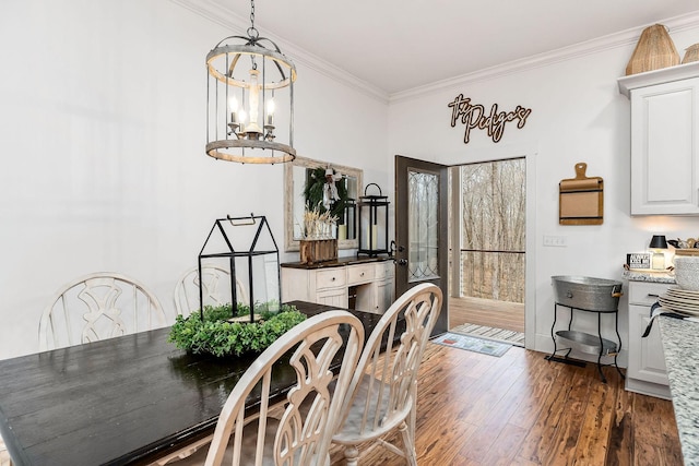 dining space featuring crown molding, dark hardwood / wood-style flooring, and a notable chandelier