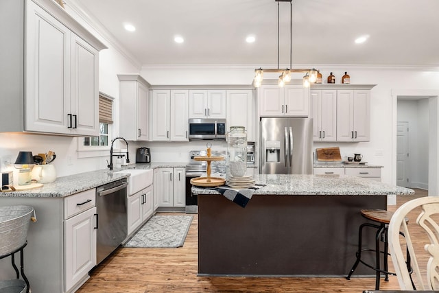 kitchen featuring a kitchen island, appliances with stainless steel finishes, sink, and a kitchen breakfast bar