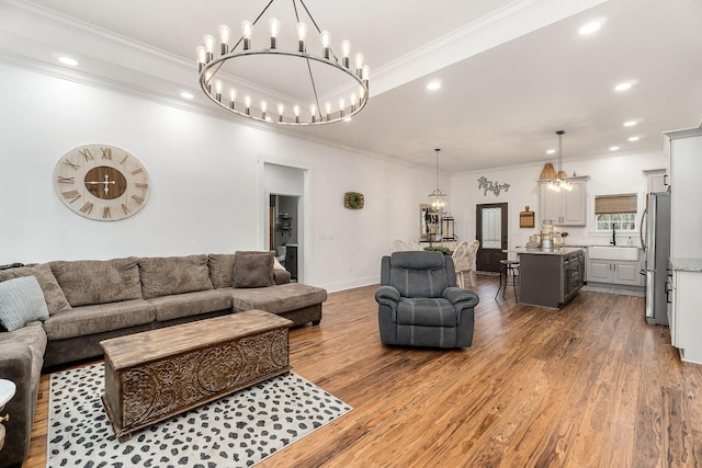 living room featuring crown molding, sink, and hardwood / wood-style floors