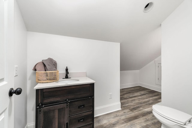 bathroom with vanity, lofted ceiling, wood-type flooring, and toilet