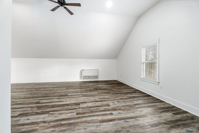 additional living space with heating unit, vaulted ceiling, dark hardwood / wood-style floors, and ceiling fan